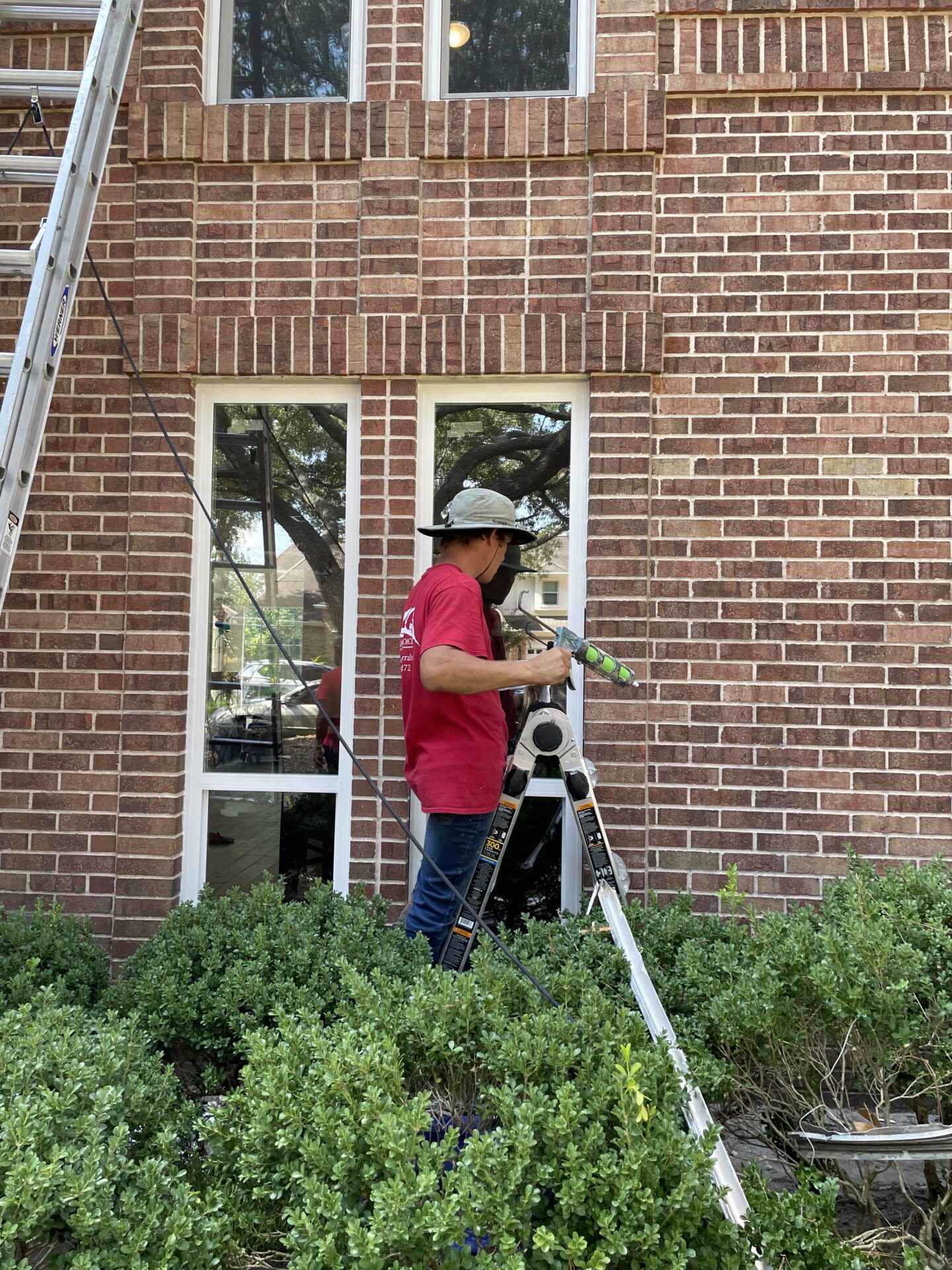 White vinyl replacement windows installed on a brick home in League City Texas by America’s Choice Windows.